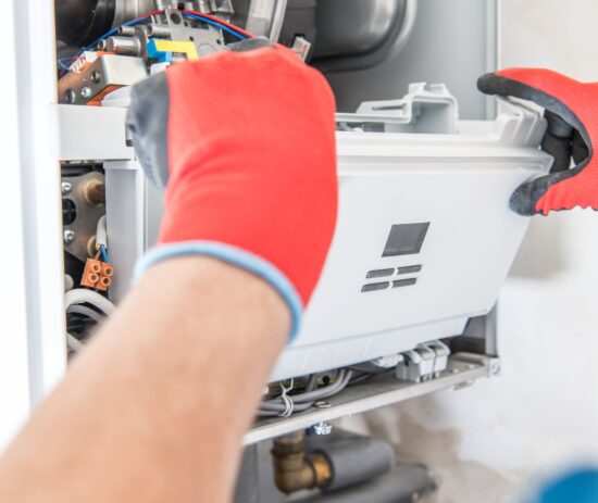 Heating engineer servicing and repairing a domestic boiler as part of a heating servicing and repairs framework delivered through a social housing framework provider.